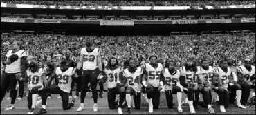  ?? ELAINE THOMPSON / ASSOCIATED PRESS FILE (2017) ?? Houston Texans players kneel and stand during the singing of the national anthem before their Oct. 29 game against the Seattle Seahawks in Seattle.