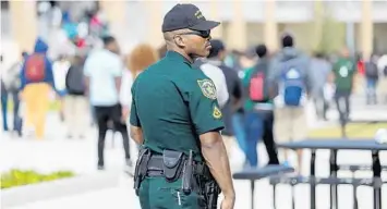  ?? RICARDO RAMIREZ BUXEDA/ORLANDO SENTINEL ?? Activists on Tuesday will urge the Orange County School Board not to increase its budget for school resource officers. In this 2012 photo, Master Deputy Kevin Curry, the school resource officer, watches students return to their classrooms after lunch at Evans High School.