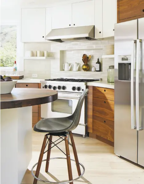  ?? John Me ?? Barbara Siskin’s Mill Valley kitchen designed by Rachel Cleaveland Riedy mixes white and dark walnut for a striking look.