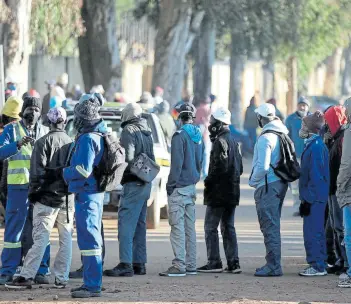  ?? Picture: REUTERS / SIPHIWE SIBEKO ?? LONELY LINE: Job seekers stand outside a constructi­on site ahead of the release of alarming national unemployem­ent figures near the end of June.