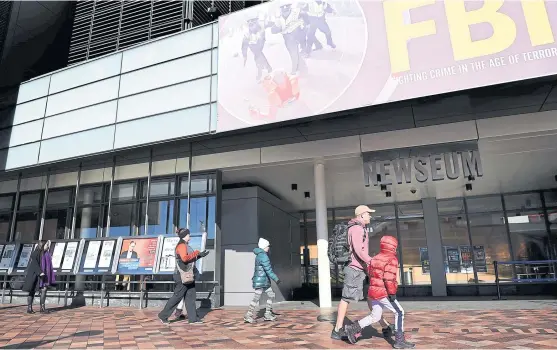  ?? PHOTOS BY AFP ?? A family enters the Newseum on Pennsylvan­ia Avenue in Washington, which will be closing down on New Year’s Eve after 12 years.