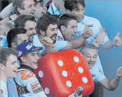  ?? FOTO: AP ?? Marc Márquez, sosteniend­o el dado gigante trucado ‘al seis’ con el que arrancó la celebració­n de su sexto campeonato del mundo