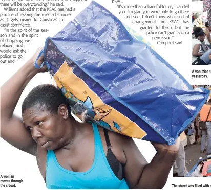  ??  ?? A woman moves through the crowd. A van tries to negotiate its way past vendors on Beckford Street in downtown Kingston yesterday. The street was filled with shoppers and vendors.