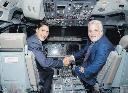  ?? GRAHAM HUGHES/THE CANADIAN PRESS ?? Prime Minister Justin Trudeau, left, and Quebec Premier Philippe Couillard sit in a flight simulator during a visit to CAE in Montreal on Wednesday. The federal and provincial government­s plan to give the company nearly $200 million over the next five years.