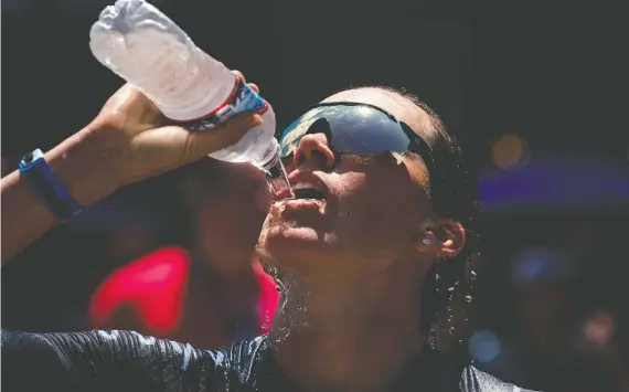  ?? KYLE RIVAS/GETTY IMAGES ?? Drinking cold water and being doused with it, like triathlete Jackie Hering during a June event in Iowa, can help with the challenges of competing in the heat.