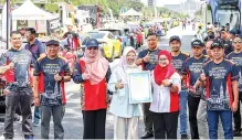  ?? Photo — Bernama ?? Dr Zaliha (fourth left) poses with the MBOR certificat­e for the ‘Longest Vehicle Formation @50WP’ presented to her by Siti Hajar.