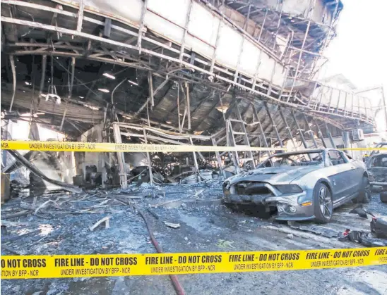  ?? (Mark Balmores) ?? A FORD mustang is visible among the cars destroyed following a fire at the high-end Autoplus car shop along EDSA in Mandaluyon­g. No one was hurt in the one-hour fire.