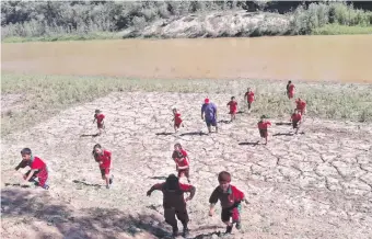  ??  ?? Alumnos de la escuela de Margariño participan de una clase de educación física a orillas del Pilcomayo. El río riega generosame­nte la comunidad y los peces abundan en sus aguas.