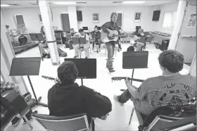  ?? NWA Democrat-Gazette/J.T. WAMPLER ?? David Singleton, guitar teacher at the Arkansas Arts Academy, plays Thursday along with his students in Rogers. The charter school is making changes in preparatio­n for next school year, including replacing about 20 percent of its staff. For photo...