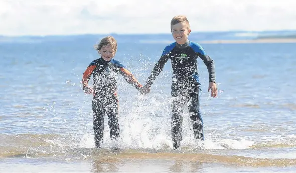  ??  ?? Enjoying a day at Monifieth Beach during the warm weather in July were seven-year-old Fearne Curry and Findlay Curry, 8.