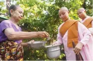  ??  ?? Buddhist nuns from the Mingalar Thaikti nunnery collect alms in Yangon.