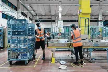 ?? Gianni Cipriano / New York Times files photo ?? Amazon employees are seen at a delivery station in Arzano, just outside Naples, Italy, in this September photo. The company has added 427,300 employees in 10 months, bringing its global work force to more than 1.2 million.