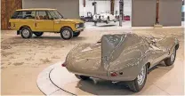  ??  ?? Im Vordergrun­d ist ein legendärer Jaguar D-Type zu sehen. Im Hintergrun­d erhalten Kunden Einblick in die Werkstatt.