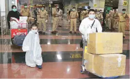  ?? PHOTO:PTI ?? Indian nationals who were stranded in Riyadh step out of Karipur airport, Kozhikode, Kerala, after arriving on a special Air India flight carrying 153 passengers