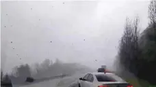  ??  ?? Cars are seen on a road during a tornado in Mountainbu­rg, Arkansas. — Reuters