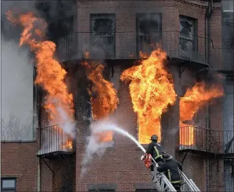  ?? CHRISTOPHE­R EVANS — BOSTON HERALD, FILE ?? Boston firefighte­rs battle a multi-alarm fire in a Beacon Street brownstone on March 26, 2014. Boston firefighte­rs Michael R. Kennedy and Lt. Edward J. Walsh were killed in the fire that ripped through the brownstone.
