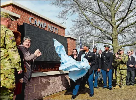  ?? SARAH GORDON/THE DAY ?? Hillhouse High School Junior ROTC member Juan Patterson helps unveil the new sign Monday at the dedication of Camp Nett in Niantic.