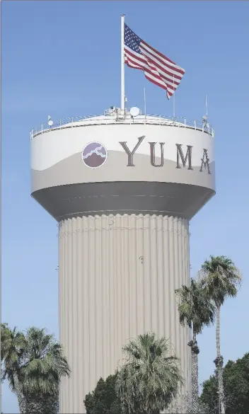  ??  ?? AS IS THE TRADITION FOR THE FOURTH OF JULY observance, an American flag flies high atop the City of Yuma water tank at Friendship Park early Friday morning.