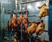  ??  ?? Barbecued poultry hangs right at the counter at BBQ Corner in Jusgo Food Court in Duluth.