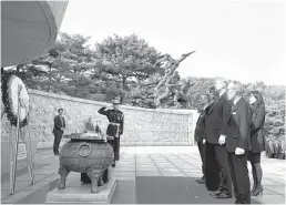  ?? Bloomberg ?? President Donald Trump and his wife, Melania, participat­e in a wreathlayi­ng ceremony at the National Cemetery in Seoul, South Korea.