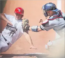  ?? Chris Lee St. Louis Post-Dispatch ?? YASMANI GRANDAL tags out Cardinals rookie Paul DeJong, who had sought to score on a Dodgers error in the seventh inning at Busch Stadium.