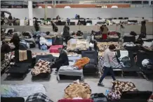  ?? AP photo ?? Ukrainian refugees rest at a refugee center in Nadarzyn, near Warsaw, Poland on Tuesday. Nearly a year has passed since the Feb. 24, invasion sent millions of people fleeing across Ukraine’s border into neighborin­g Poland, Slovakia, Hungary, Moldova and Romania.