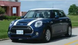  ?? KATHY RENWALD FOR THE TORONTO STAR ?? The stripes are extra, but the Mini Cooper S strikes a perfect tone against a perky pink beach house on Lake Michigan, along the Indiana Dunes National Lakeshore.