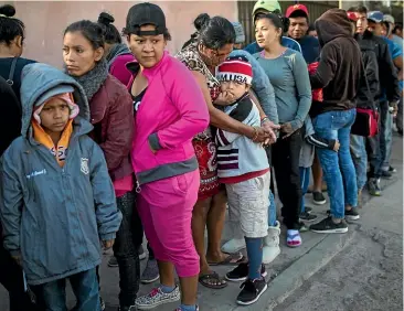  ?? AP ?? Central American migrants wait in line for a donated breakfast at a temporary shelter in Tijuana, Mexico. The mayor of Tijuana has called the migrants’ arrival an "avalanche" that the city is ill-prepared to