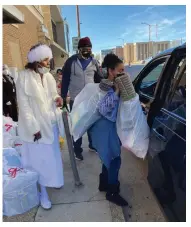  ?? Bluff Commercial/Byron Tate) (Pine ?? Saint Mary Harris (left), pastor of House of Bread Church, directs traffic Monday as the church conducts a food giveaway. “A lot of people are out of jobs and children are home,” she said. “It’s a difficult time.”