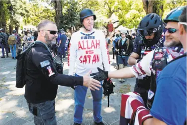  ?? Noah Berger / Special to The Chronicle ?? Jim Gilles (center), who traveled from Evansville, Ind., to see Ann Coulter in Berkeley, before she canceled, speaks with fellow conservati­ves April 27 in the city’s Martin Luther King Jr. Civic Center Park.