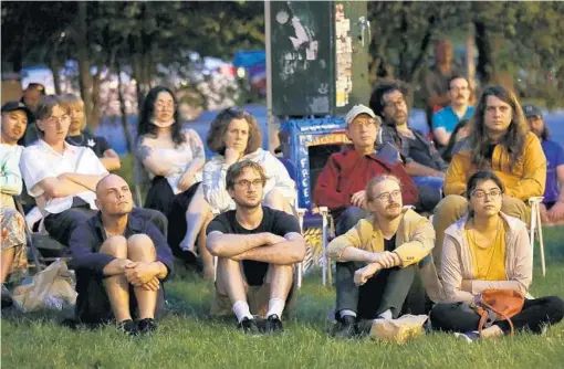  ?? CHRIS SWEDA/CHICAGO TRIBUNE PHOTOS ?? People watch as the Chicago Film Society presents an outdoor screening outside the Comfort Station in Logan Square on July 7.