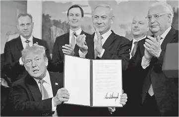  ??  ?? Trump holds a proclamati­on recognisin­g Israel’s sovereignt­y over the Golan Heights as he is applauded by Netanyahu and others during a ceremony in the Diplomatic Reception Room at the White House in Washington, US. — Reuters photo