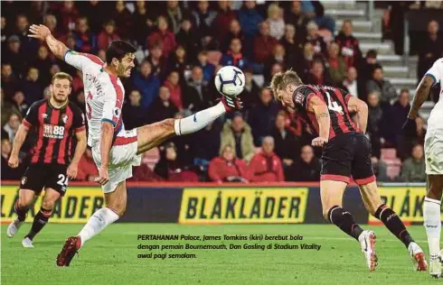  ??  ?? PERTAHANAN Palace, James Tomkins (kiri) berebut bola dengan pemain Bournemout­h, Dan Gosling di Stadium Vitality awal pagi semalam.