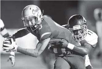  ?? STAFF PHOTO BY DOUG STRICKLAND ?? McMinn County’s Jalen Hunt tackles Ooltewah’s Andrew Manning during their game at Ooltewah High School on Thursday.