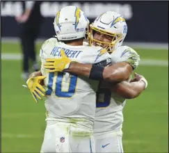  ?? Associated Press ?? WELL DONE — Chargers tight end Hunter Henry, right, embraces quarterbac­k Justin Herbert (10) after defeating the Las Vegas Raiders 30-27 in overtime on Thursday in Las Vegas.