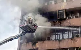  ?? — PTI ?? Smoke billows out of Lok Nayak Bhavan in New Delhi on Saturday as firefighte­rs try to extinguish the fire that broke out on the 6th floor of the building.