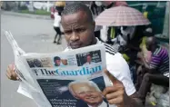  ??  ?? Reading the news in Lagos, Nigeria