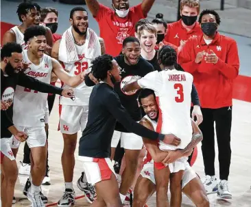  ?? Karen Warren / Staff photograph­er ?? Cougars guard DeJon Jarreau (3) gets a hug from Justin Gorham (4) after a win over Memphis last month.