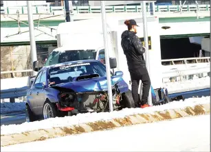  ?? Ernest A. Brown photo ?? A man stands near his vehicle after it crashed onto the median on Route 10 southbound in Providence after sliding on an icy patch Tuesday. For the most part, road conditions have improved but icy conditions still made their presence felt in Valley towns.