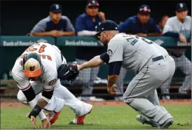  ?? The Associated Press ?? Seattle Mariners relief pitcher Marc Rzepczynsk­i, right, tags out Baltimore Orioles’ Manny Machado as he tries to reach home on Jonathan Schoop’s single the eighth inning in Baltimore on Wednesday.