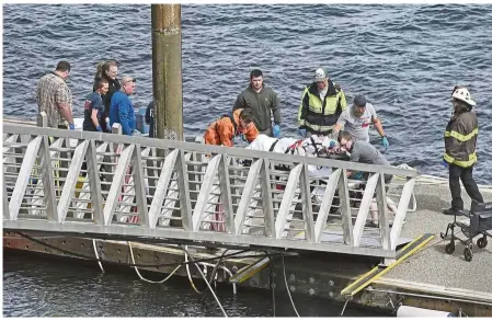  ??  ?? Safe and sound: Emergency response crews transporti­ng an injured passenger to an ambulance at the George Inlet Lodge docks in Ketchikan, Alaska. — AP