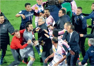  ?? — AP ?? Paris Saint Germain’s goalkeeper Salvatore Sirigu (left) is held off by a club member as he confronts Evian players after their French league match in Annecy, French Alps, on Sunday. PSG won 1-0.