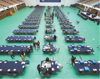  ?? Yonhap ?? National Election Commission staffers conduct a final test on ballot counting machines ahead of the 20th presidenti­al election, at a polling station set up at Seoul National University in Gwanak District, Tuesday.