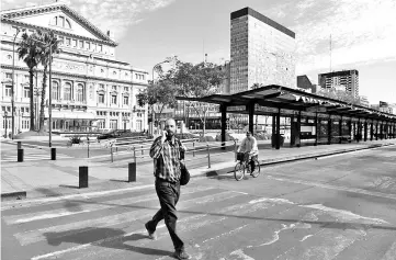  ??  ?? A man crosses the empty 9 de Julio avenue in Buenos Aires, during a 24 hours general strike on September 25. With no public transport or taxis running, Tuesday’s strike was largely respected, as many shops remained closed and citizens found themselves unable to get to work. — AFP photo