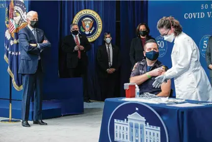  ?? Saul Loeb / AFP via Getty Images ?? President Joe Biden watches as nurse Elizabeth Galloway administer­s a COVID-19 vaccine to Washington, D.C., firefighte­r Corey Hamilton during an event marking the 50 millionth dose administer­ed since Biden was sworn in.