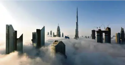  ?? (TOM DULAT/GETTY IMAGES) ?? Les tours de Dubaï, aux Emirats, émergeant du brouillard.