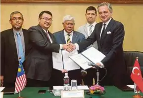  ?? PIC BY MOHD FADLI HAMZAH ?? CyberSecur­ity Malaysia chief executive officer Datuk Dr Amirudin Abdul Wahab (second from left) shaking hands with May Cyber Teknoloji chairman Mehmet Ali Yalcindag after signing a memorandum of understand­ing in Putrajaya yesterday. With them is...