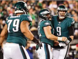  ?? ABBIE PARR / GETTY IMAGES ?? Eagles quarterbac­k Nick Foles (9) is congratula­ted by center Jason Kelce and guard Brandon Brooks (79) after a Philadelph­ia touchdown during Sunday night’s dismantlin­g of the Minnesota Vikings.