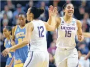  ?? THE ASSOCIATED PRESS ?? Connecticu­t's Saniya Chong, left, and Gabby Williams celebrate a basket against UCLA during the first half of Saturday's NCAA tournament regional semifinal in Bridgeport, Conn. The Huskies won 86-71.