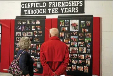  ?? KRISTI GARABRANDT — THE NEWS-HERALD ?? Marilyn and Richard Kretschman look at one of the memory boards set up as part of the Strolling Through the Years display in the gymnasium at Garfield Elementary School. Marilyn is a former teacher at Garfield and the Kretschman­s children attended the...